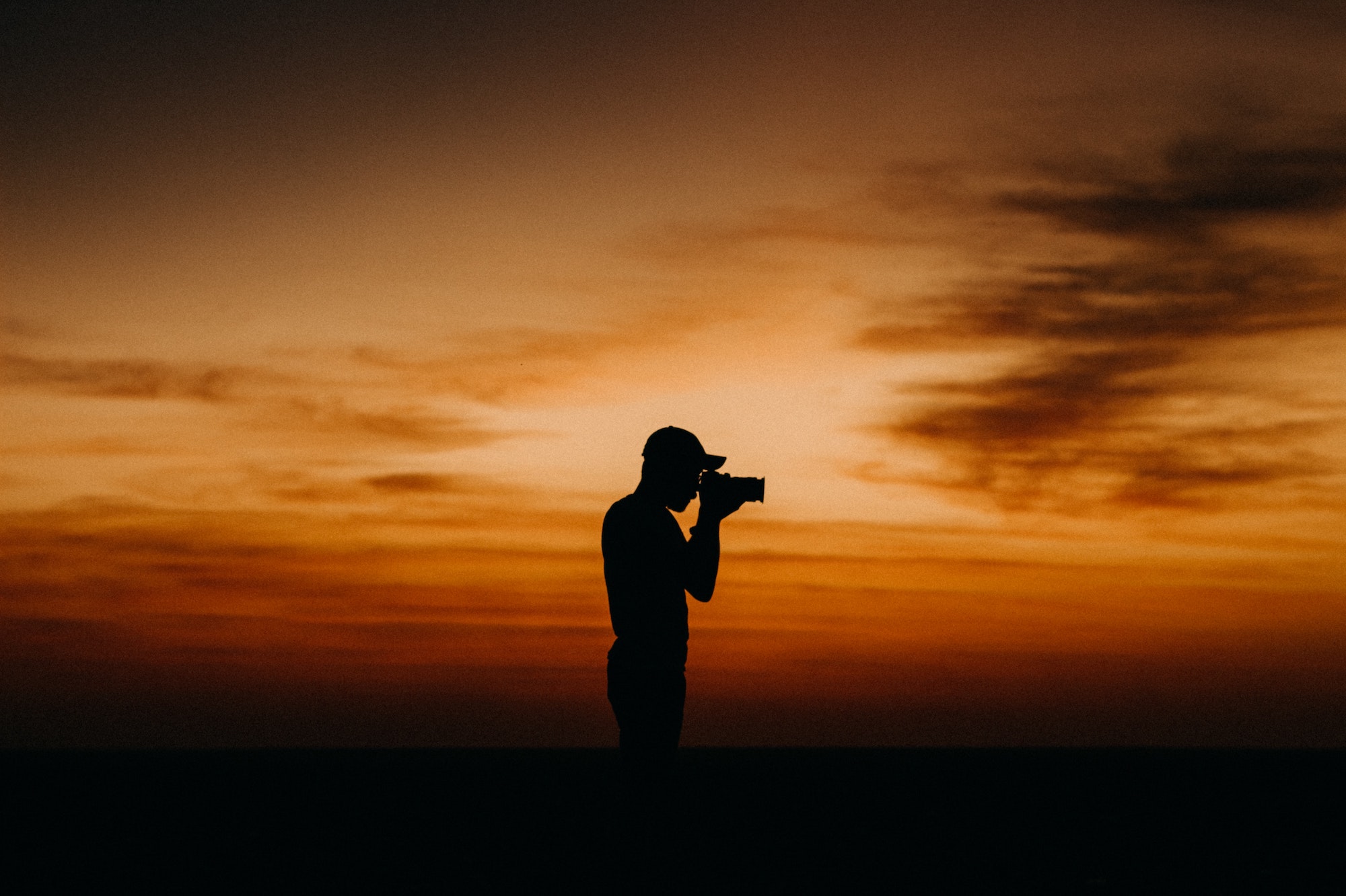 Man taking picture with sunset